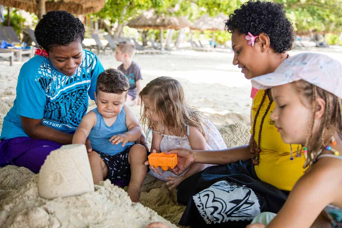 Castaway Island Fiji team members building sandcastles with children
