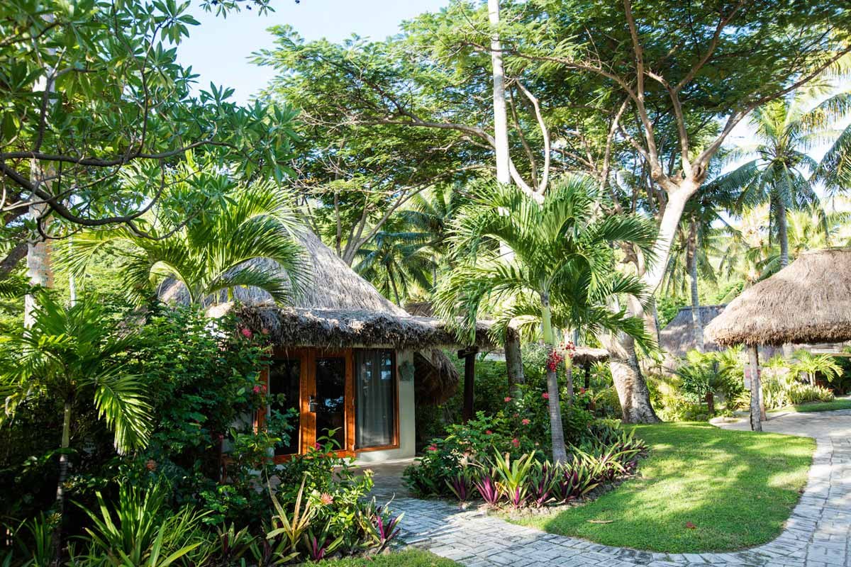 Thatched Island Bure surrounded by tropical gardens at Castaway Island Fiji