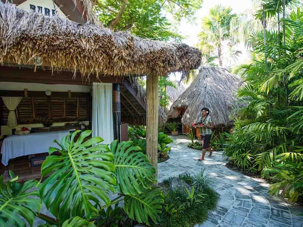 Thatched massage bures in tropical gardens at Castaway Island Fiji