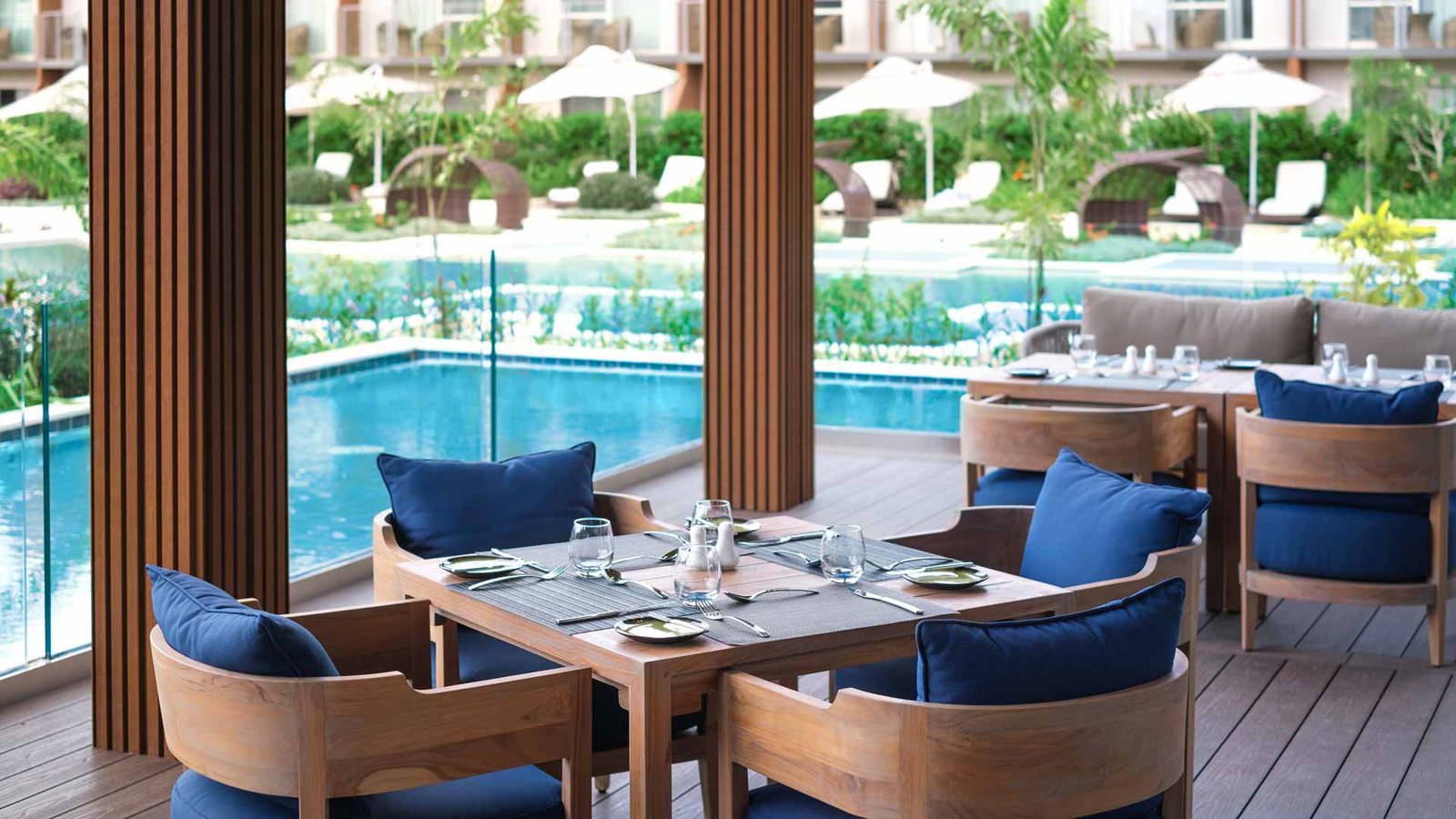 Restaurant tables looking across a resort pool at Crowne Plaza Fiji