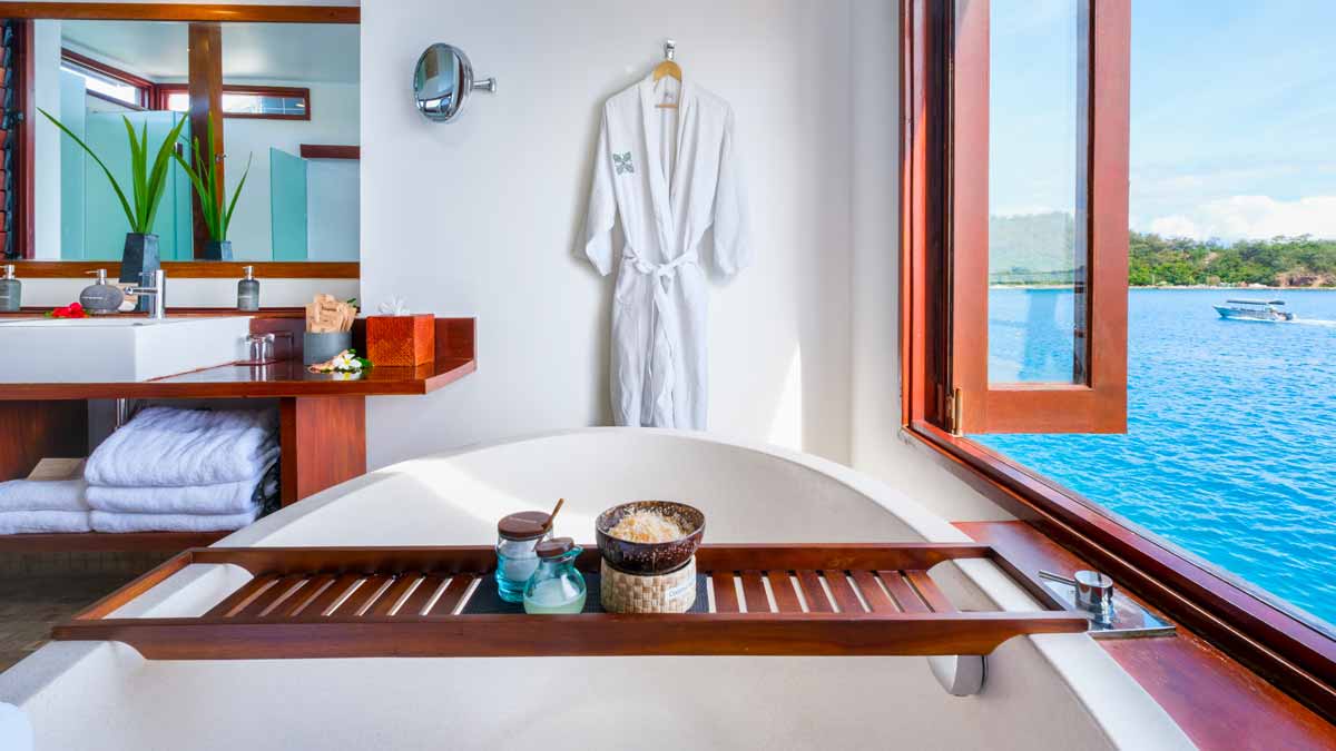 Bathtub with lagoon views in an Over-Water Bure at Likuliku Lagoon Resort