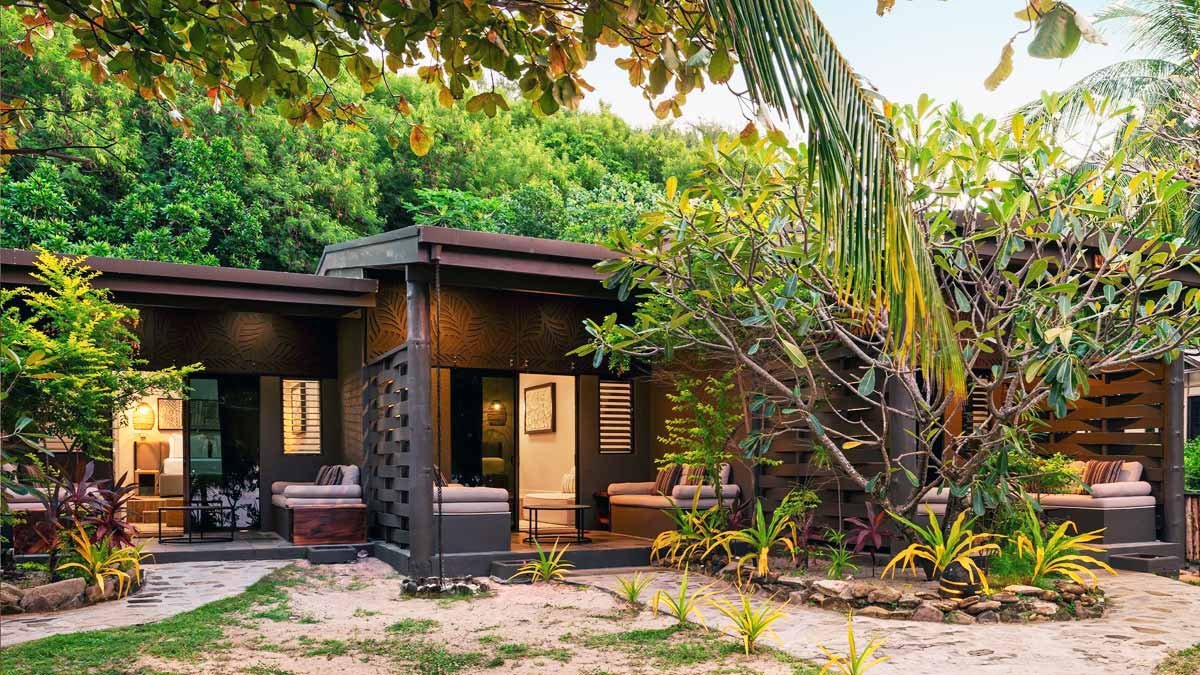 Private timber villa deck framed by tropical gardens at Mantaray Island Resort