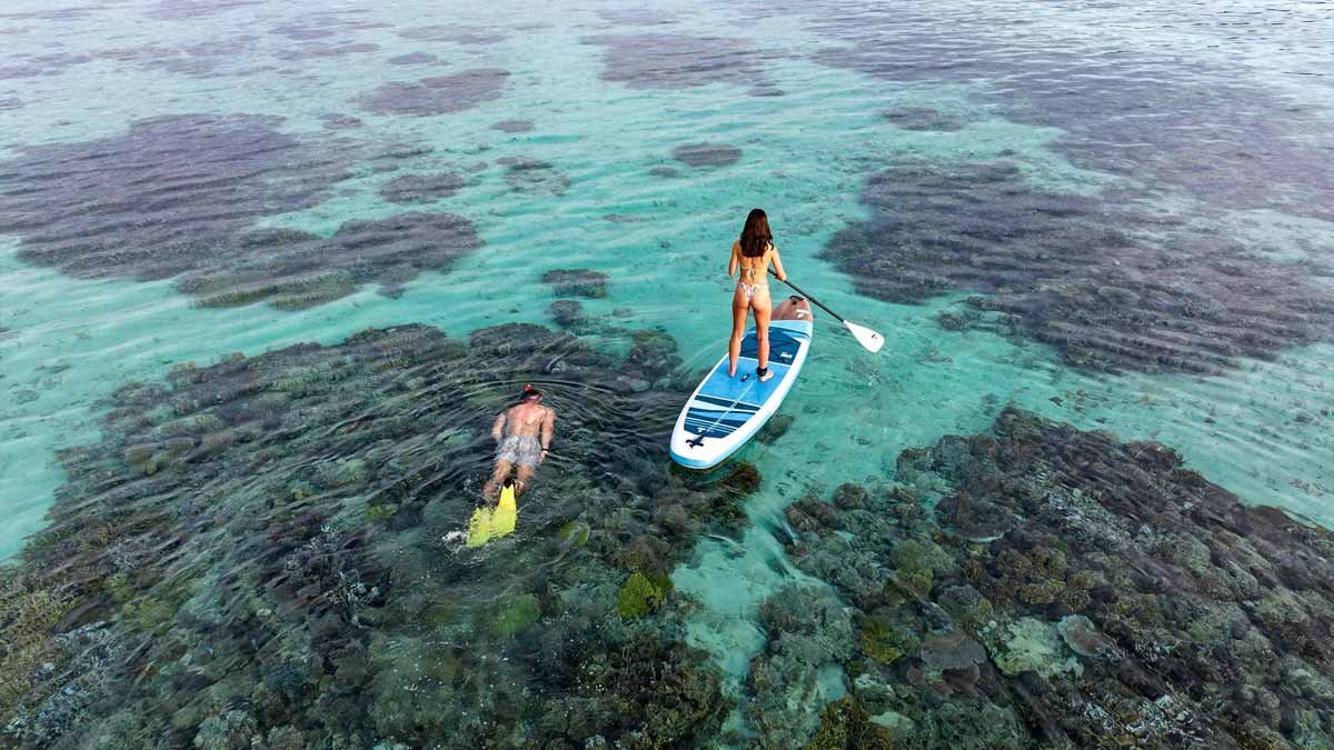 A paddleboarder and snorkeller above the reef at Mantaray Island Resort