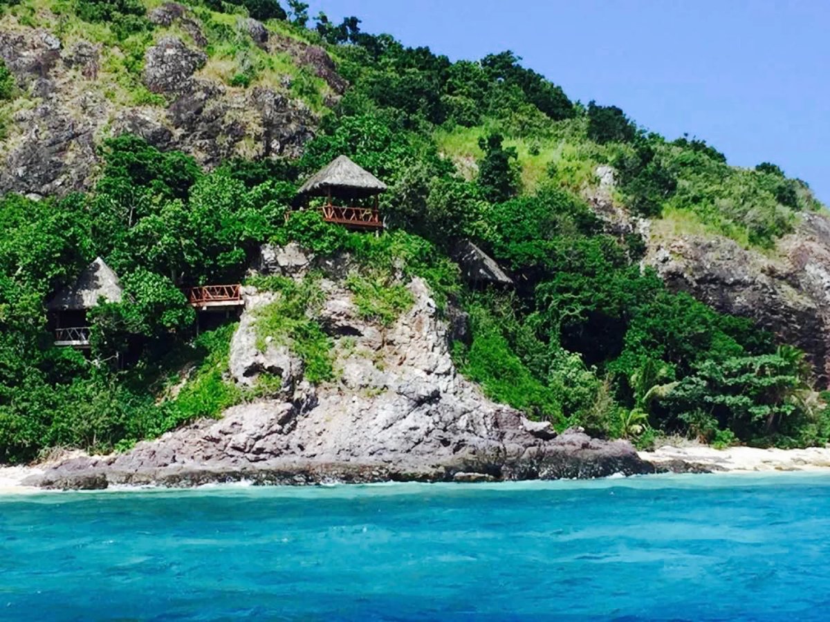 Thatched spa pavilions above the rocky shoreline at Matamanoa Island Resort