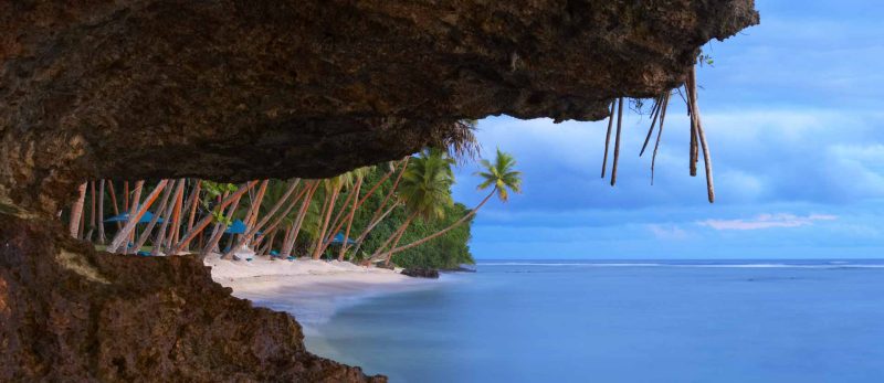Rock overhang framing the beach and sea at Namale Resort
