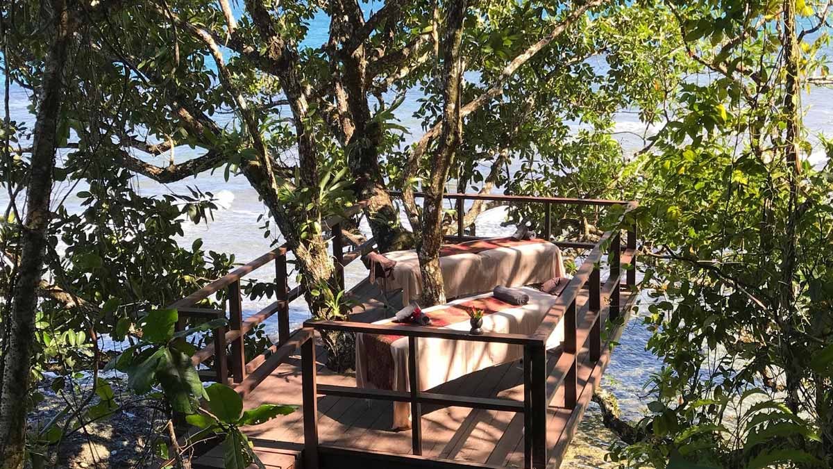 Open-air massage tables among the trees at Nanuku Resort Fiji