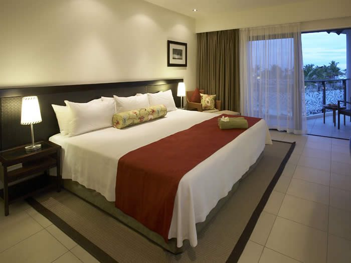 Guest bedroom opening to a balcony at Radisson Blu Resort Fiji