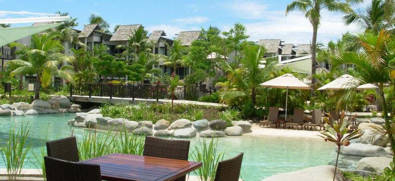 Outdoor tables beside a lagoon-style pool at Radisson Blu Resort Fiji