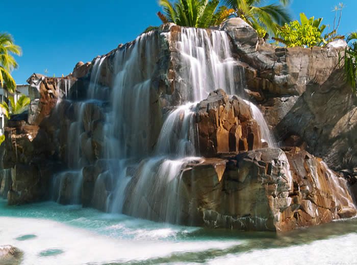 Cascading water over a rock feature beside a Radisson Blu Fiji pool