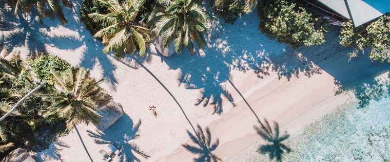 Palm-fringed beach and clear shallows at Savasi Island Resort