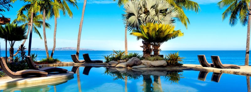 Palm-fringed pool beside the ocean at Sheraton Fiji Golf & Beach Resort