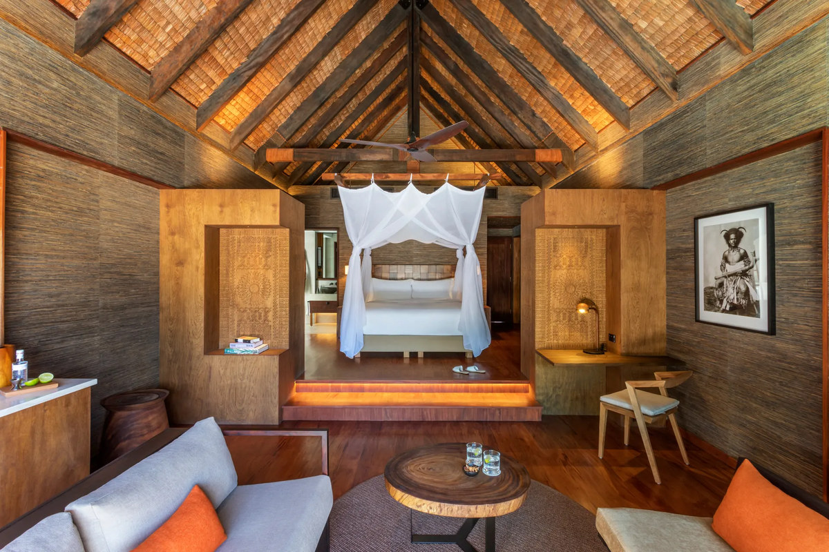 Timber-lined bedroom and living area in a Hideaway Pool Villa at Six Senses Fiji