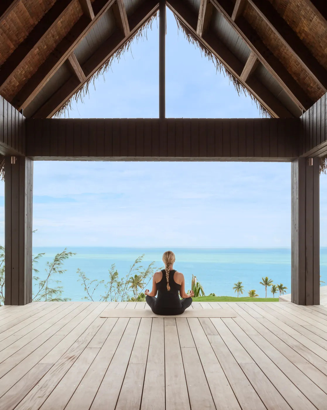 A guest meditating in an open-sided pavilion overlooking the sea at Six Senses Fiji
