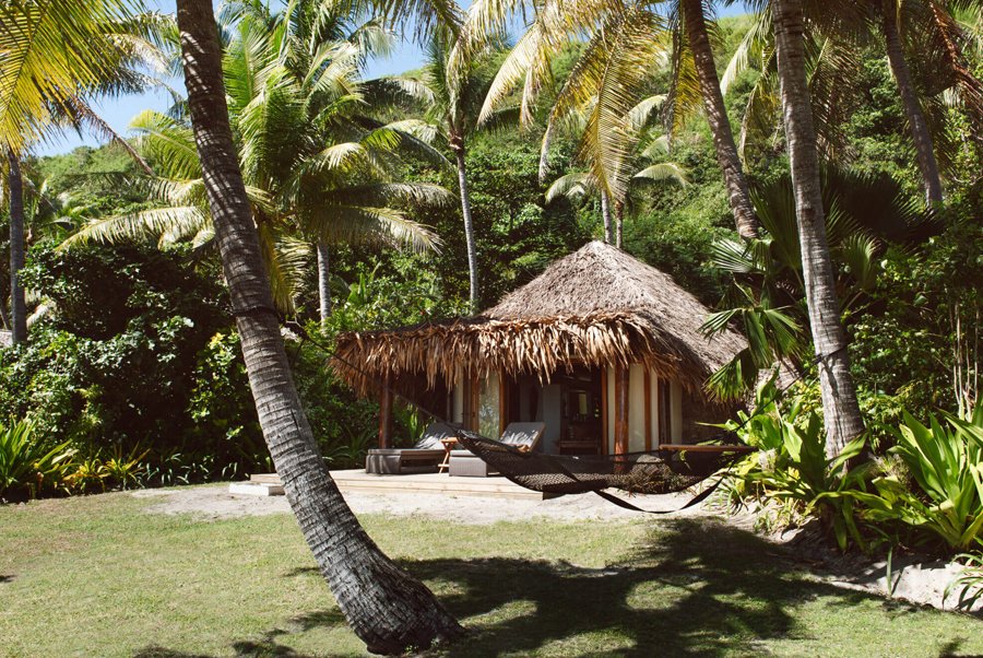 Beachfront Bure and hammock among palms at Tokoriki Island Resort