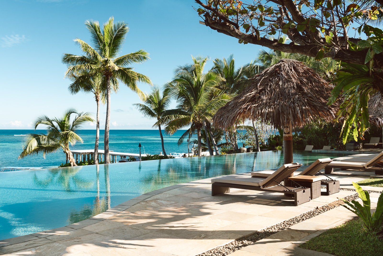 Infinity-edge pool, sun loungers and ocean view at Tokoriki Island Resort