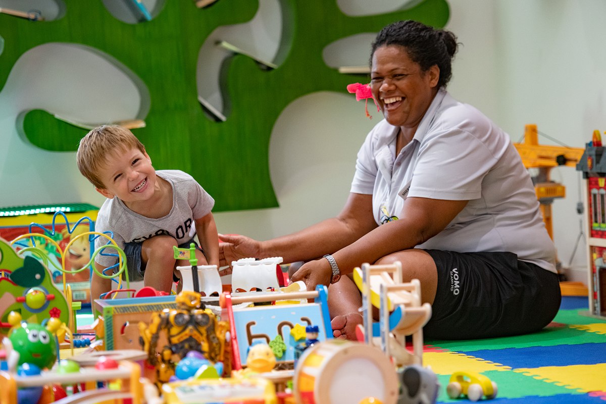 A VOMO Island Resort team member playing with a child in the Kids Village