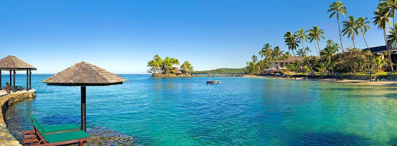 Blue lagoon and palm-fringed shoreline at The Warwick Fiji