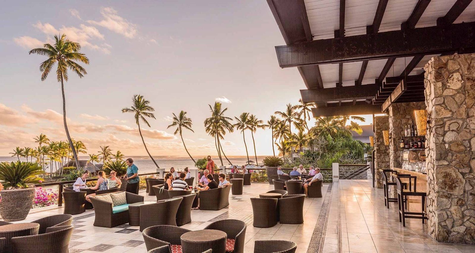 Outdoor terrace seating with sunset views at The Warwick Fiji