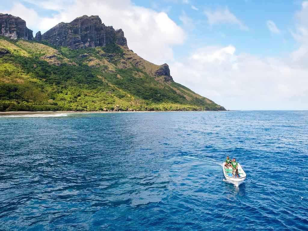 Boat beside the dramatic mountainous coast of Waya Island