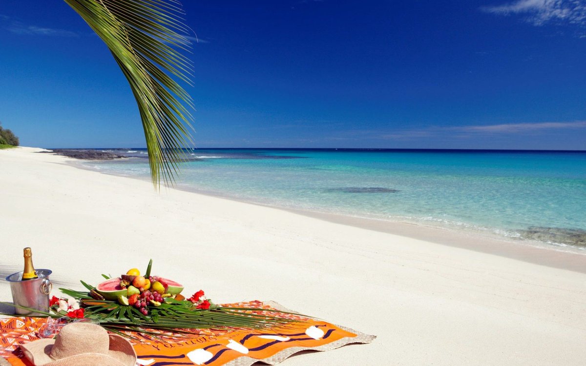 A beach picnic beside clear turquoise water in the Yasawa Island Resort collection