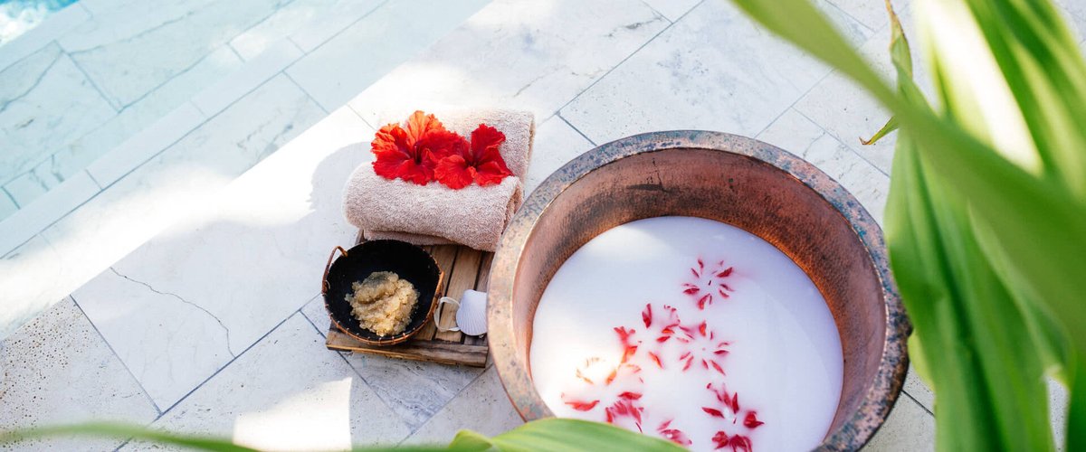 Tropical flowers, towels and a treatment bowl prepared for a Yasawa Island Resort spa experience